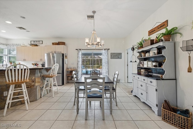 tiled dining area with a chandelier