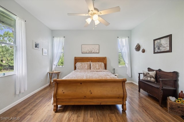 bedroom with multiple windows, ceiling fan, and dark hardwood / wood-style flooring