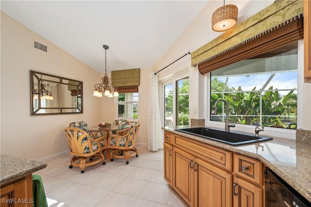 kitchen featuring light stone countertops, vaulted ceiling, pendant lighting, an inviting chandelier, and sink