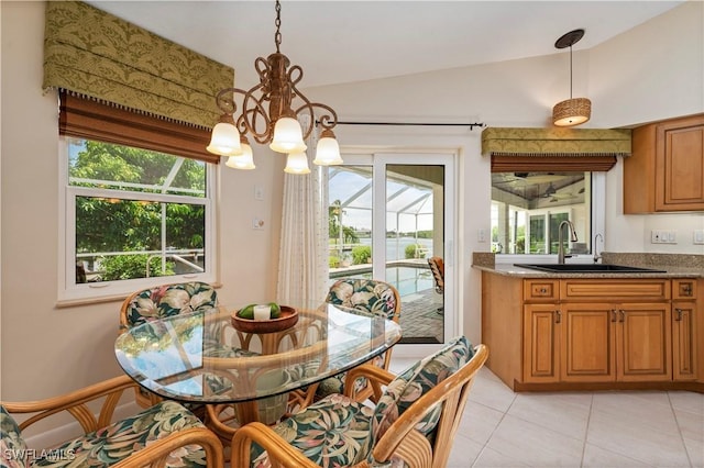 dining room with light tile patterned flooring, vaulted ceiling, a chandelier, and sink