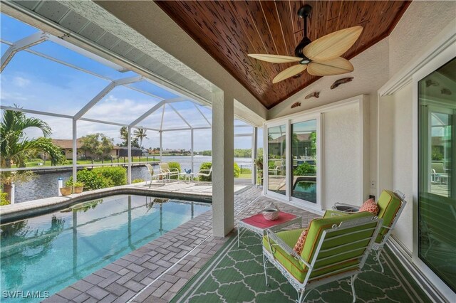 view of pool with a lanai, a patio area, and a water view