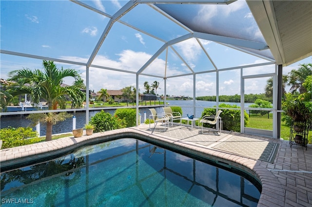 view of pool featuring a patio, glass enclosure, and a water view