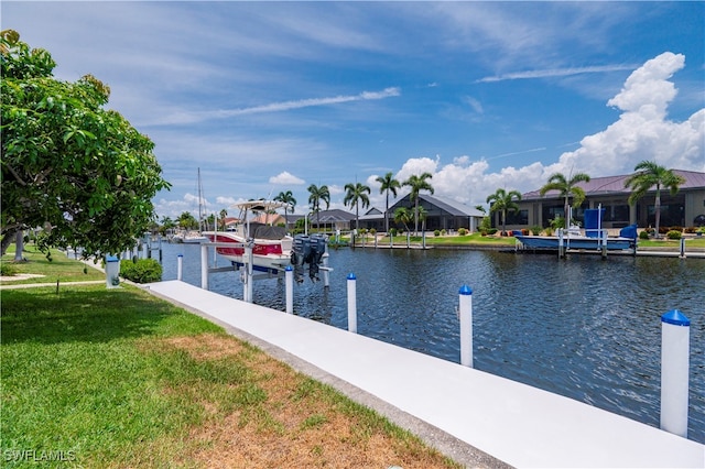 dock area with a lawn and a water view