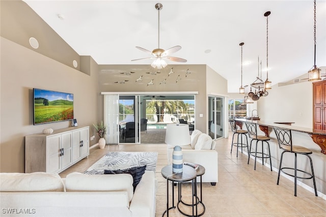 tiled living room with ceiling fan and high vaulted ceiling