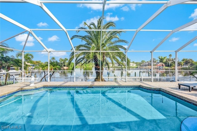 view of swimming pool with glass enclosure and a water view