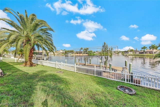 view of dock featuring a lawn, a water view, and an outdoor fire pit