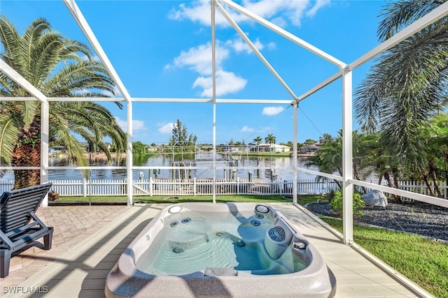 view of swimming pool featuring a patio, glass enclosure, a water view, and an outdoor hot tub