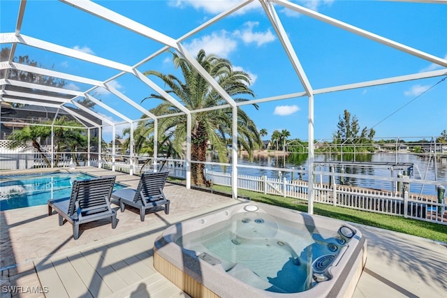 view of patio with a lanai, a swimming pool with hot tub, and a water view