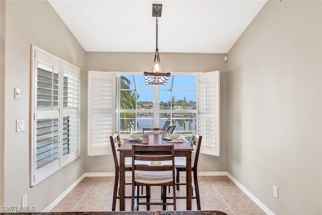 tiled dining room with a chandelier