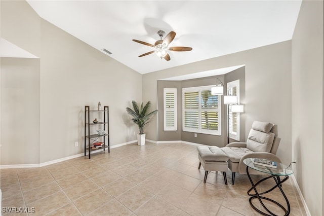 living area with ceiling fan, light tile patterned flooring, and lofted ceiling