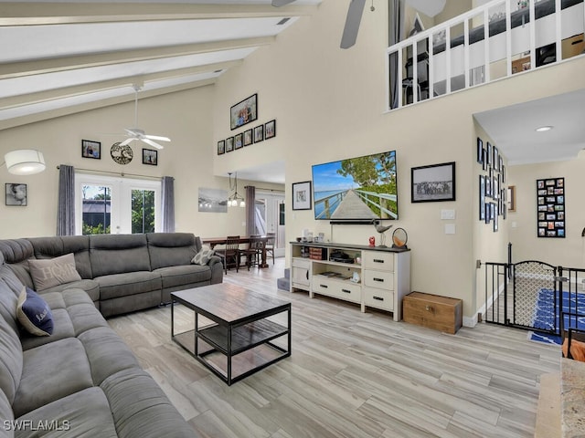 living room featuring light wood-type flooring, beamed ceiling, high vaulted ceiling, ceiling fan, and french doors