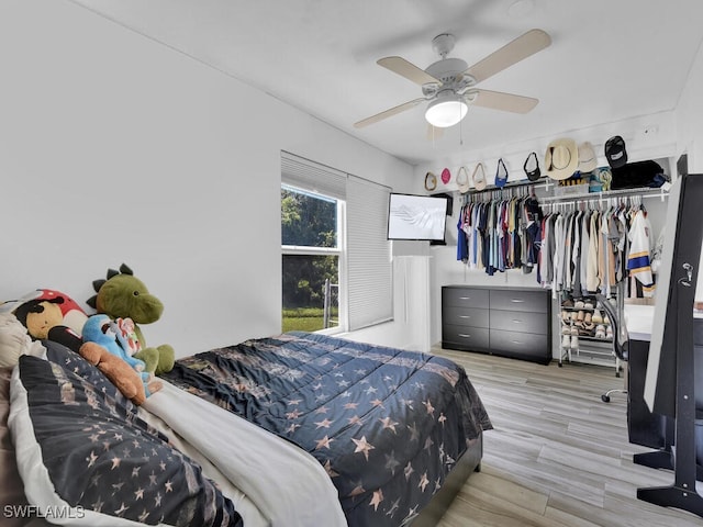 bedroom with ceiling fan, light hardwood / wood-style flooring, and a closet