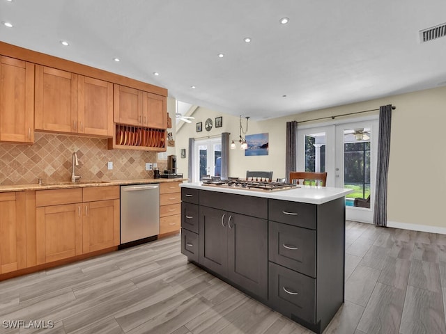 kitchen with appliances with stainless steel finishes, light hardwood / wood-style floors, sink, and french doors