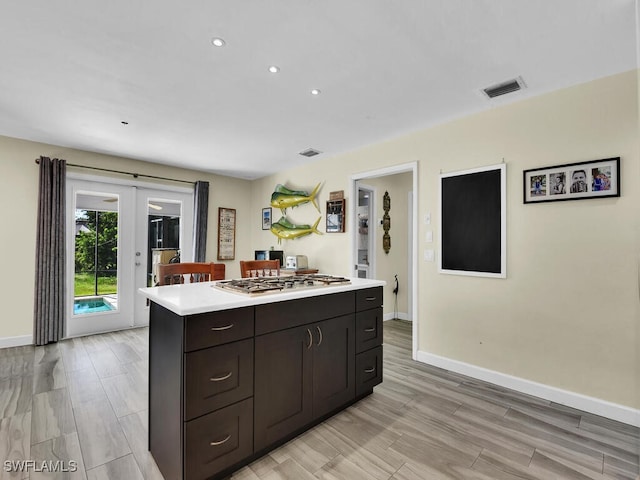 kitchen with french doors, light hardwood / wood-style flooring, dark brown cabinetry, and stainless steel gas cooktop