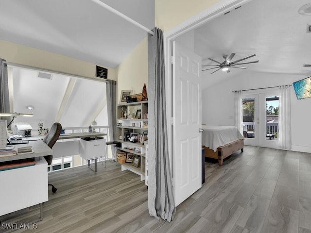 bedroom featuring lofted ceiling, light hardwood / wood-style floors, access to exterior, and french doors