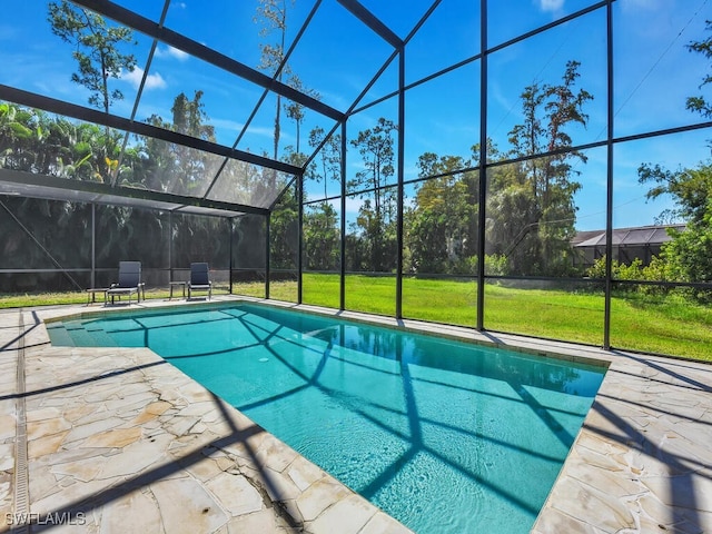 view of pool with glass enclosure, a yard, and a patio area