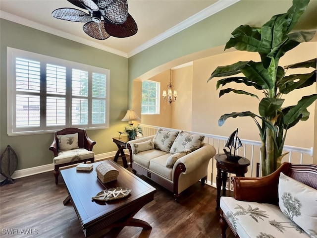 living room with ceiling fan with notable chandelier, dark hardwood / wood-style flooring, and crown molding