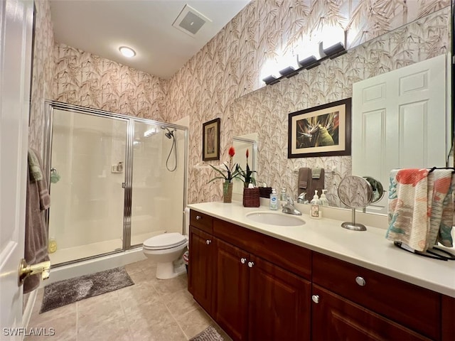 bathroom with tile patterned flooring, vanity, toilet, and walk in shower