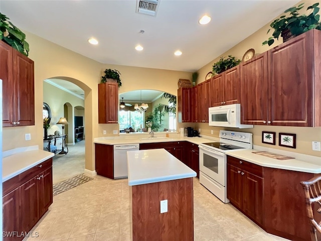 kitchen with a center island, sink, white appliances, and light tile patterned flooring