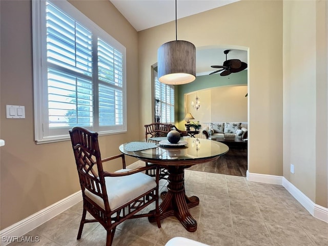 tiled dining area featuring lofted ceiling and ceiling fan