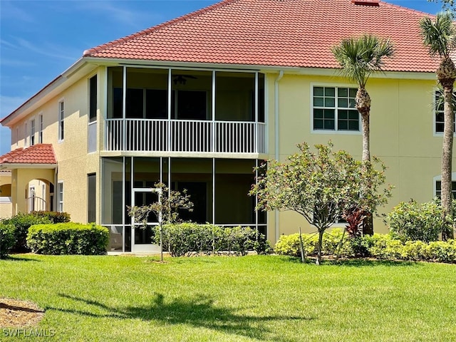 back of house with a yard and a balcony