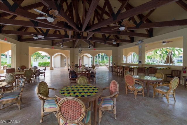 dining space featuring high vaulted ceiling, ceiling fan, concrete floors, and beamed ceiling