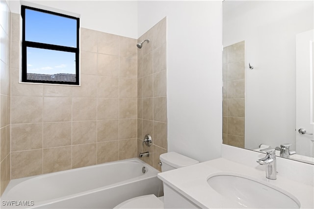 full bathroom with tiled shower / bath, vanity, and toilet