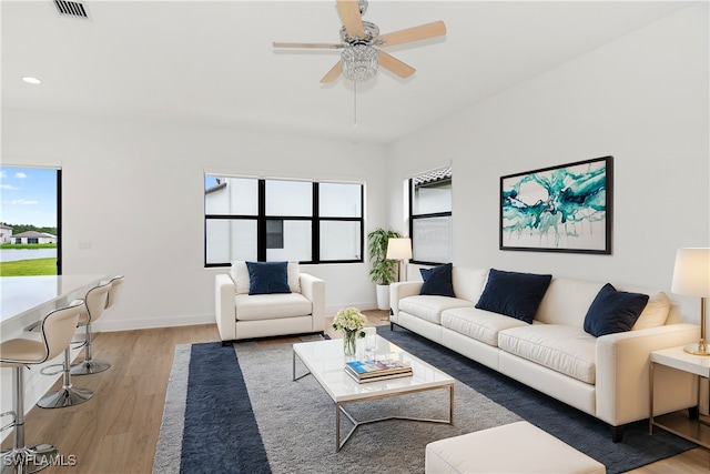 living room with ceiling fan, hardwood / wood-style flooring, and a healthy amount of sunlight