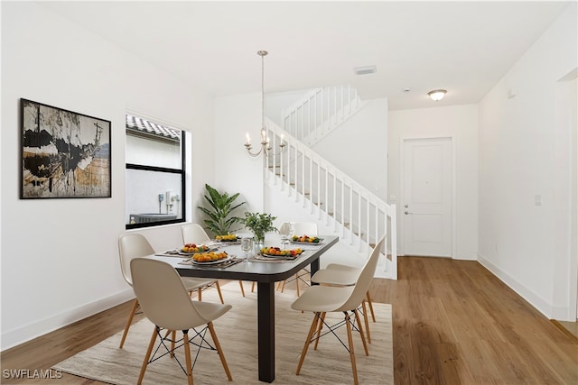 dining area with a notable chandelier and hardwood / wood-style floors