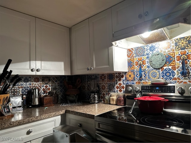 kitchen featuring stainless steel range with electric stovetop, white cabinets, custom exhaust hood, and decorative backsplash