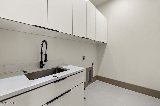 clothes washing area featuring washer hookup, electric dryer hookup, cabinets, and sink