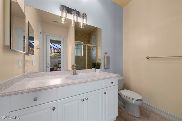 bathroom with tile patterned floors, vanity, toilet, and a shower with shower door