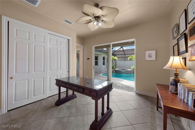 tiled office space featuring ceiling fan