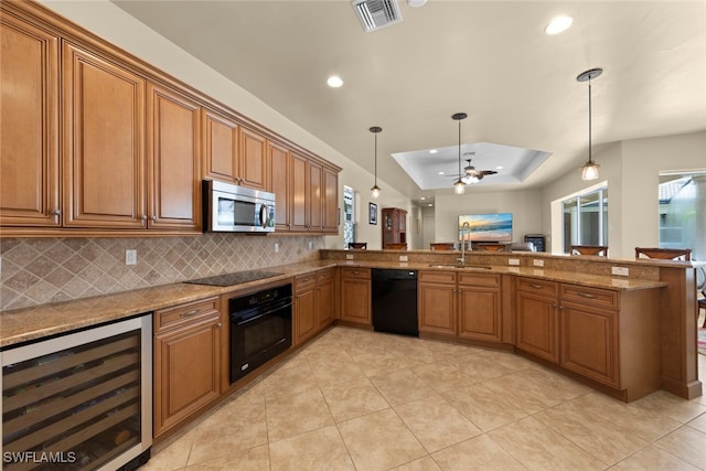 kitchen with light stone counters, decorative light fixtures, wine cooler, and black appliances