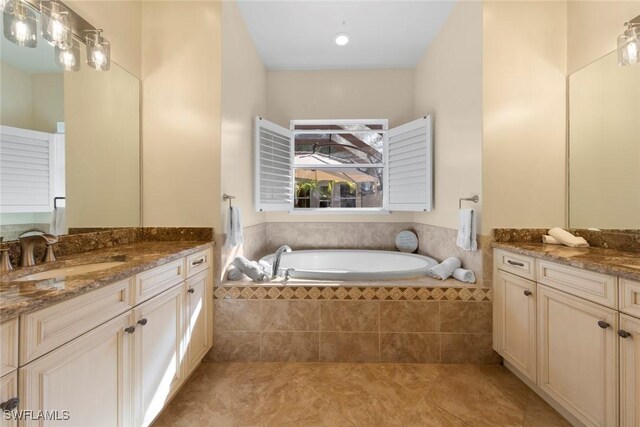 bathroom featuring tiled bath, tile patterned flooring, and vanity