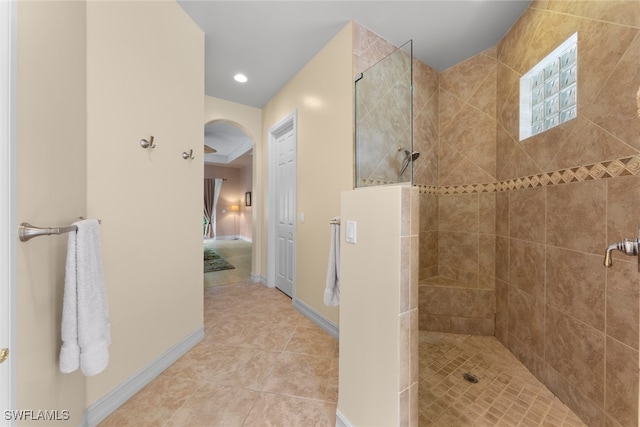 bathroom with tile patterned flooring and tiled shower