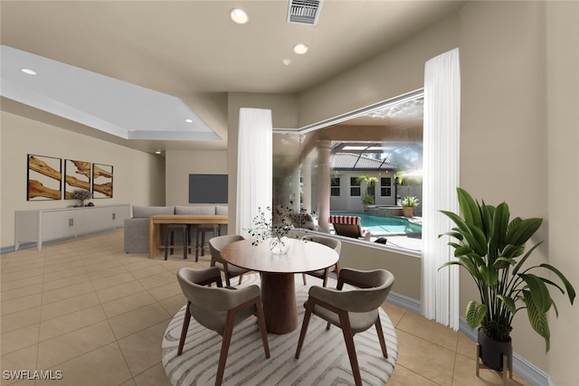 tiled dining space featuring a tray ceiling