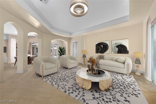 living room featuring light tile patterned floors and a tray ceiling