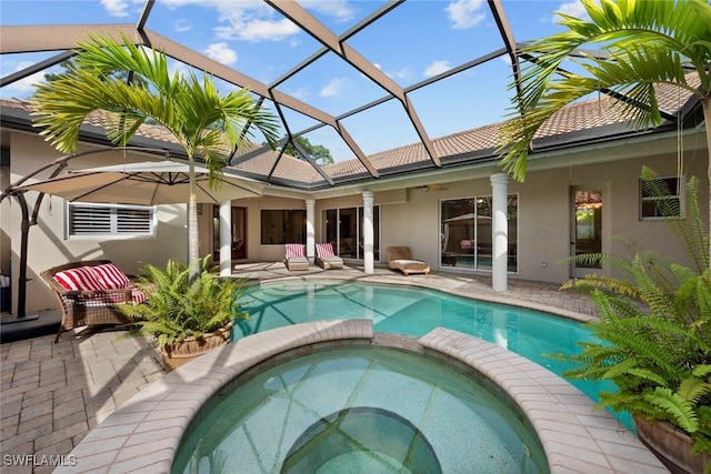 view of pool featuring a patio area, an in ground hot tub, ceiling fan, and glass enclosure