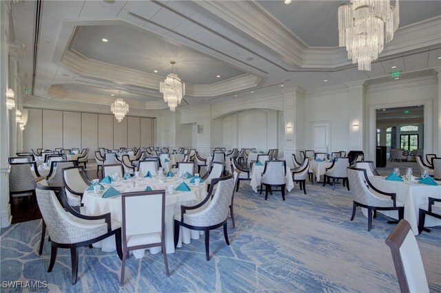 dining area featuring carpet, crown molding, a tray ceiling, and a chandelier