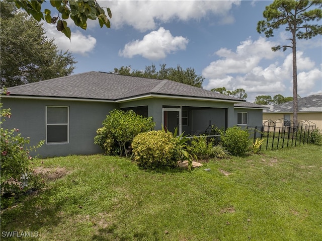 rear view of house featuring a lawn