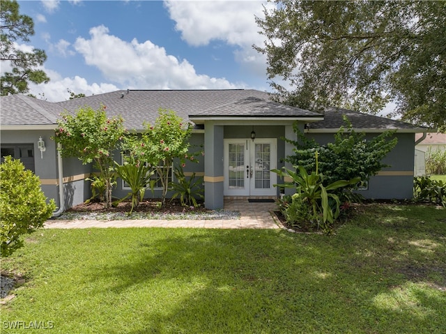 rear view of property with a lawn and french doors