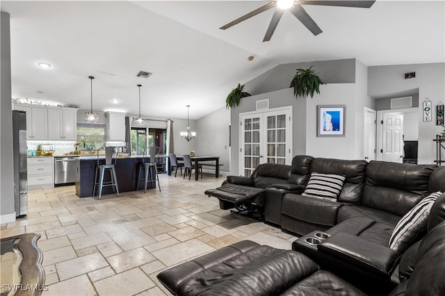 living room with lofted ceiling and ceiling fan with notable chandelier