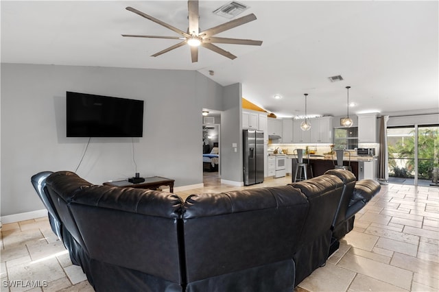 living room with ceiling fan and vaulted ceiling