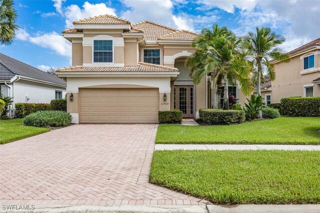 mediterranean / spanish house with a garage and a front yard