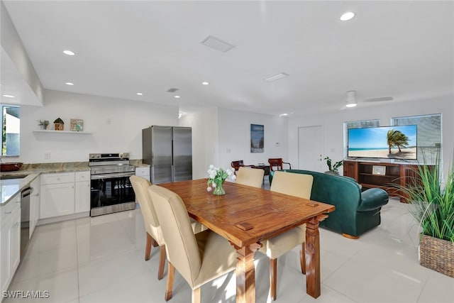 dining area featuring ceiling fan, light tile patterned flooring, and sink