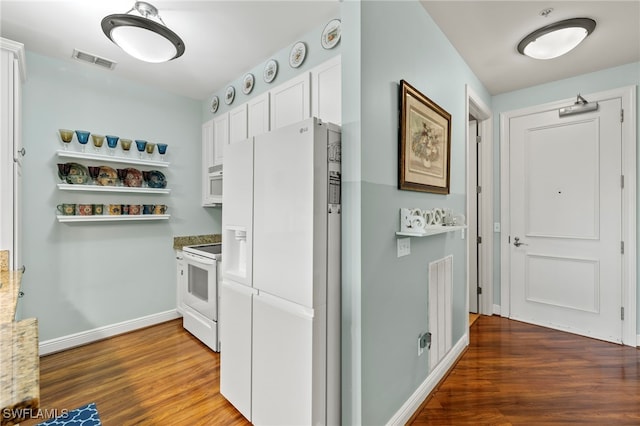 kitchen with light stone countertops, white appliances, white cabinets, and dark hardwood / wood-style flooring