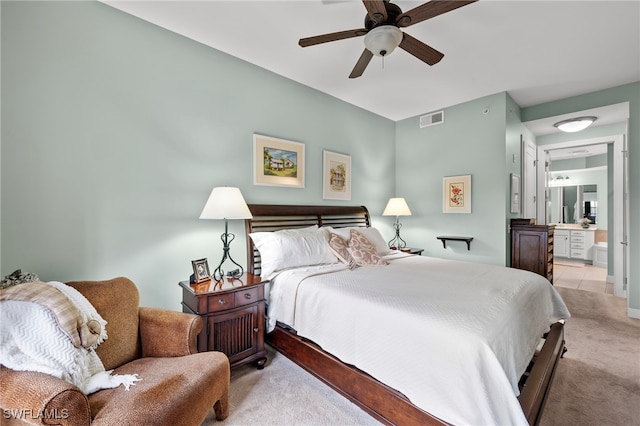 carpeted bedroom featuring ceiling fan and ensuite bath