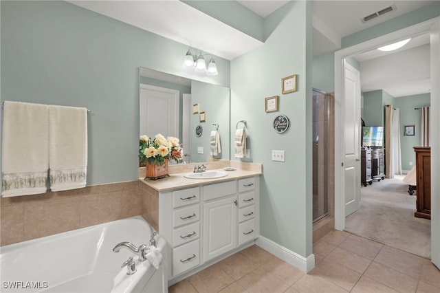 bathroom featuring tile patterned floors, vanity, and shower with separate bathtub