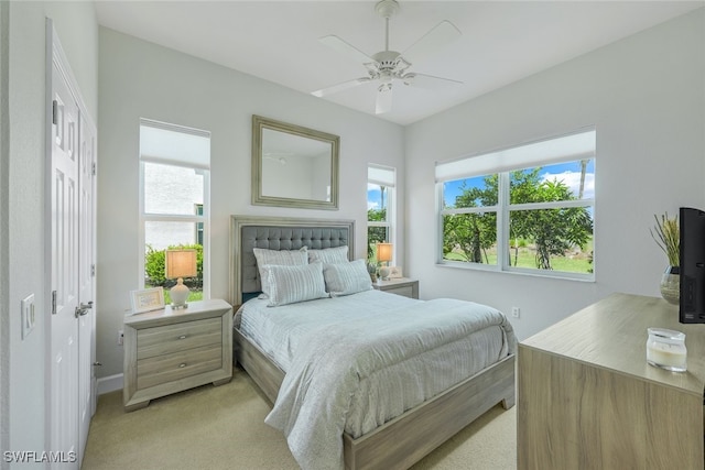 bedroom with light carpet and a ceiling fan